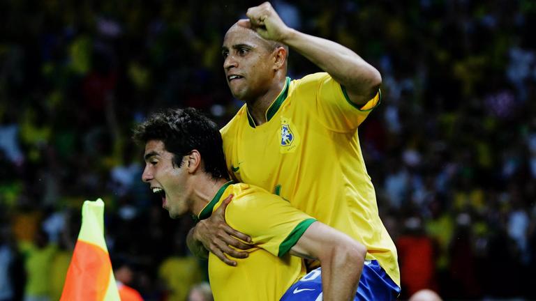 BERLIN - JUNE 13:  Kaka of Brazil celebrates scoring the opening goal with team mate Roberto Carlos (R) during the FIFA World Cup Germany 2006 Group F match between Brazil and Croatia played at the Olympic Stadium on June 13, 2006 in Berlin, Germany.  (Photo by Alex Livesey/Getty Images)