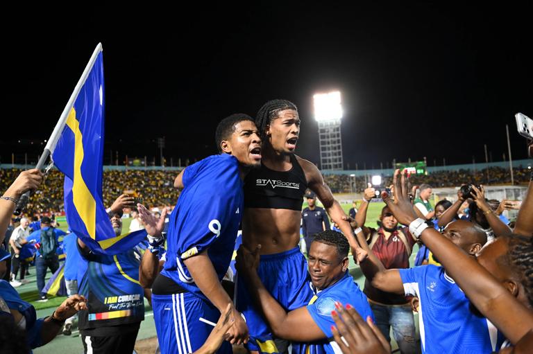 Cura&Atilde;&sect;ao players and fans celebrate World Cup 2026 qualification after a 0-0 draw with Jamaica at the National Stadium in Kingston, Jamaica on November 18, 2025. The tiny Caribbean nation of Curacao became the smallest country ever to qualify for the World Cup on November 18 as Haiti booked their return to the tournament for the first time in 52 years along with Panama.
A nerve-shredding finale to the CONCACAF qualifying campaign saw Curacao -- with a population of just 156,000 -- squeeze into next year's finals in the United States, Canada and Mexico with a 0-0 draw against Jamaica in Kingston. (Photo by Ricardo MAKYN / AFP) (Photo by RICARDO MAKYN/AFP via Getty Images)          