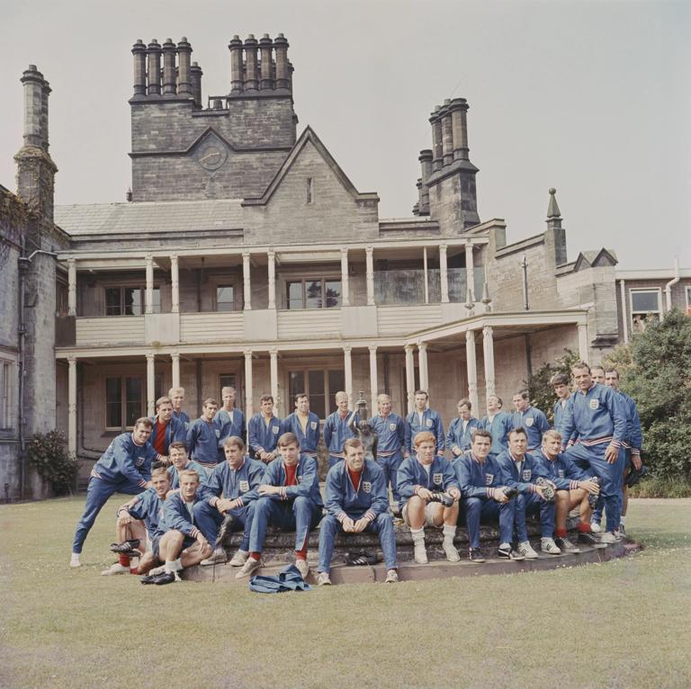 10th JUNE 1966: The England 1966 World Cup football squad and training staff posed together outside the National Recreation Centre at Lilleshall, Shropshire on 10th June 1966. Back row clockwise from left: John Connelly, Gordon Milne, Bobby Moore, Ian Callaghan, Jack Charlton, Peter Bonetti, Gordon Banks, Ron Flowers, Bobby Charlton, Jimmy Armfield, Nobby Stiles, Les Cocker, Will McGuinness, Norman Hunter, Gerry Byrne, George Cohen and Ron Springett. Front row from left: Peter Thompson, George Eastham, Johnny Byrne, Geoff Hurst, Martin Peters, Keith Newton, Alan Ball, Terry Paine, Jimmy Greaves and Roger Hunt. (Photo by Popperfoto via Getty Images/Getty Images)