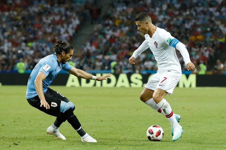 Uruguay's defender Martin Caceres (L) marks Portugal's forward Cristiano Ronaldo during the Russia 2018 World Cup round of 16 football match between Uruguay and Portugal at the Fisht Stadium in Sochi on June 30, 2018. (Photo by Odd ANDERSEN / AFP) / RESTRICTED TO EDITORIAL USE - NO MOBILE PUSH ALERTS/DOWNLOADS        (Photo credit should read ODD ANDERSEN/AFP via Getty Images)